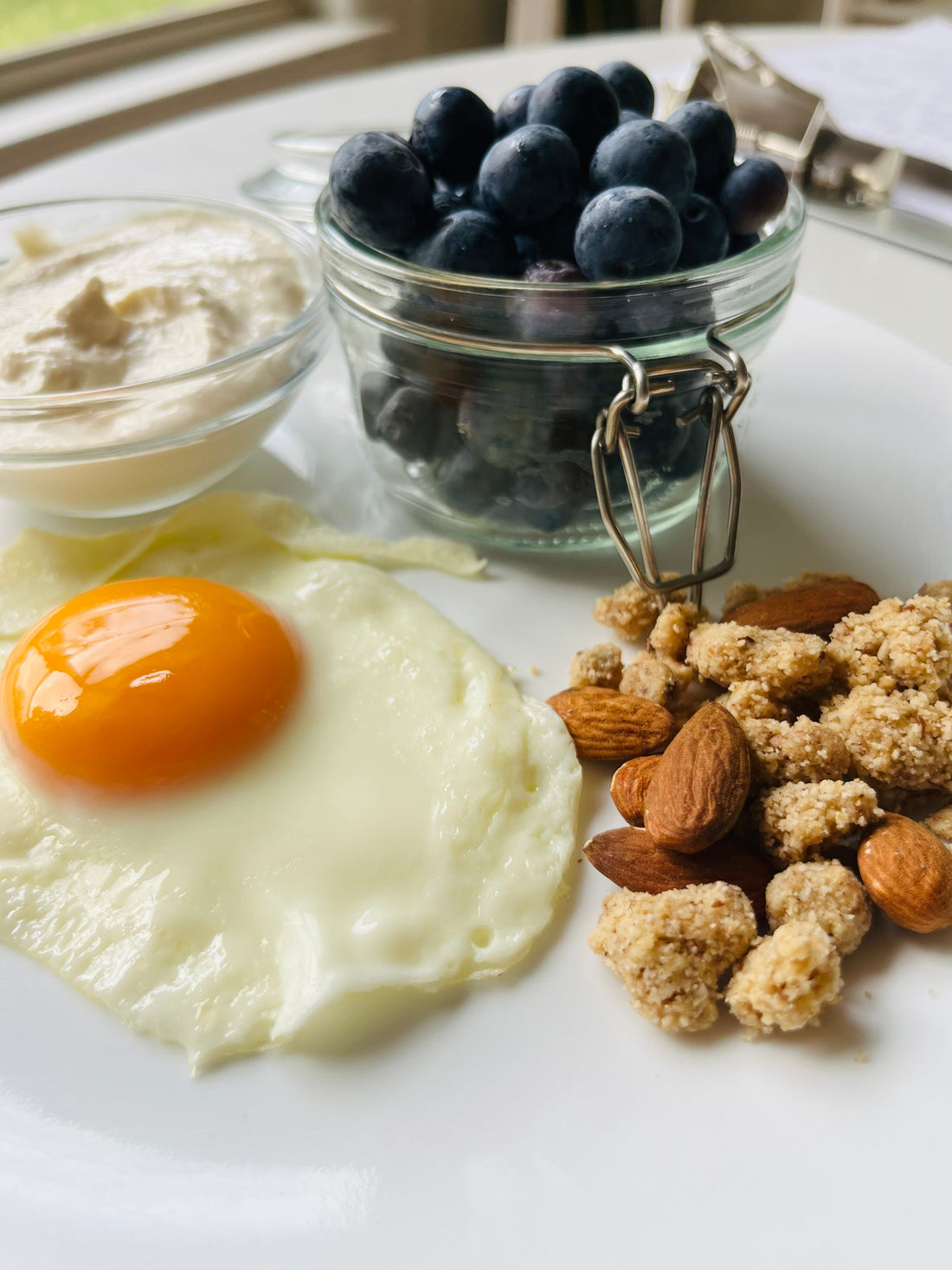 Protein-rich breakfast with a fried egg, blueberries, whipped cottage cheese and almond crumble