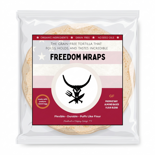 A clear plastic bag of Freedom Wraps on a plain white background. The package contains a flour tortilla and features a large front label with red, white, and light pink stripes, a black horned logo, and text including 'FREEDOM WRAPS' and 'grain free'.